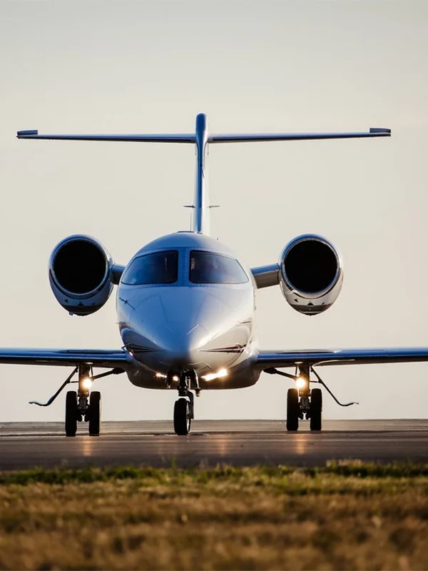 Privatjet frontal auf der Landebahn in der goldenen Stunde, Landescheinwerfer eingeschaltet