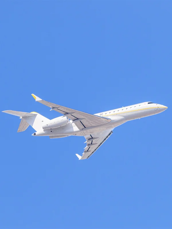 Ein großer Privatjet mit gelbem Zierstreifen steigt durch den klaren blauen Himmel