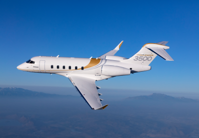 Bombardier Challenger 3500 privát jet repül egy hegyvidéki táj felett.