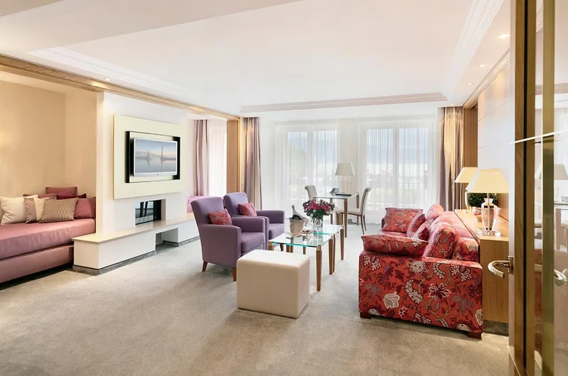 Un salon de suite avec canapé fleuri et cheminée, à l'Hôtel Bayerischer Hof de Munich