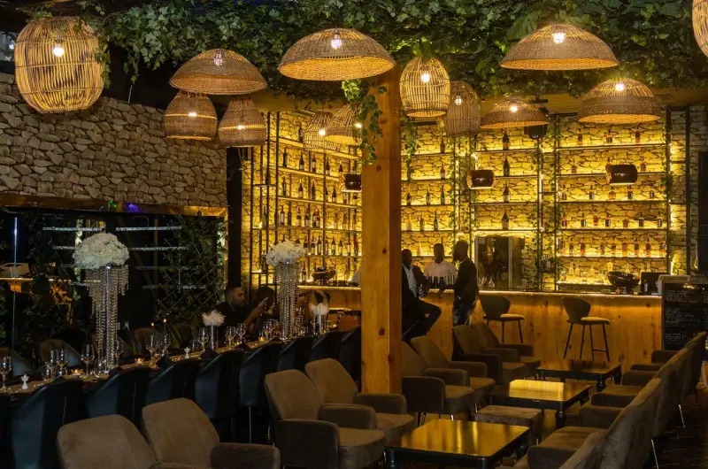 Bar de restaurant à l'éclairage ambré, avec suspensions en osier et verdure, à Istanbul