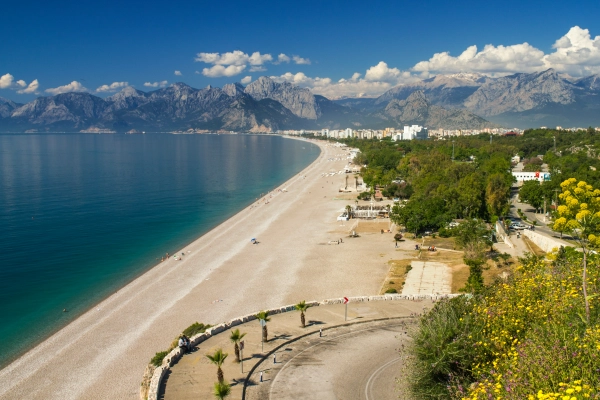 La spiaggia di Konyaaltı ad Antalya, con il Mar Mediterraneo e gli edifici della costa ai piedi dei Monti del Tauro