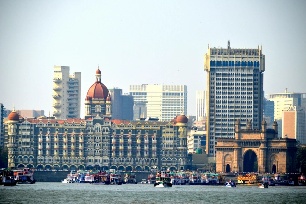 The Taj Mahal Palace and Gateway of India on Mumbai’s waterfront, with boats in the foreground