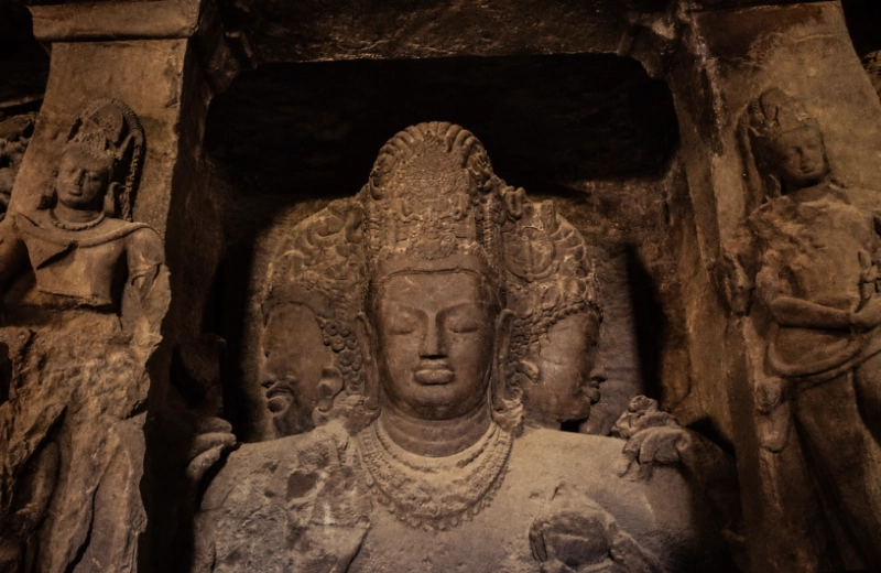 Three-faced Shiva sculpture carved into stone inside the Elephanta Caves near Mumbai