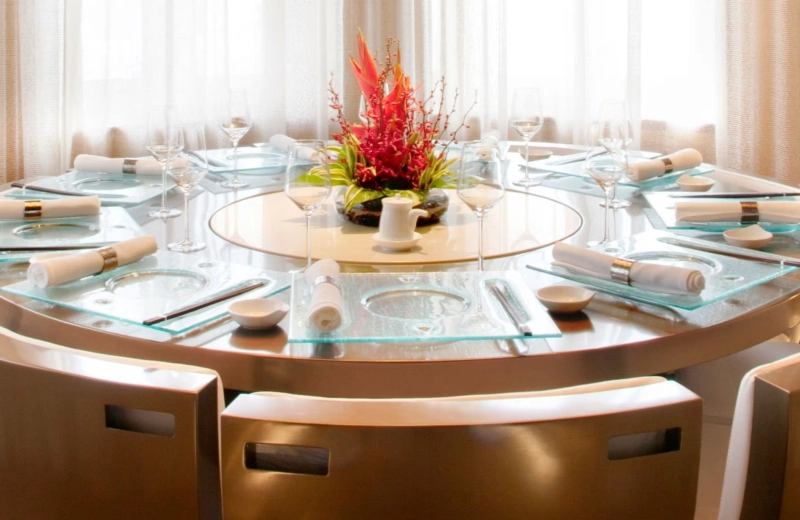 Round dining table with a red floral centrepiece at Wasabi by Morimoto, The Taj Mahal Palace, Mumbai