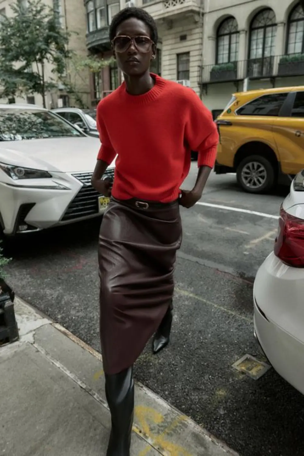 Street style outfit with vintage leather pencil skirt and red knit, showing how a real leather skirt sharpens everyday dressing with clean structure.