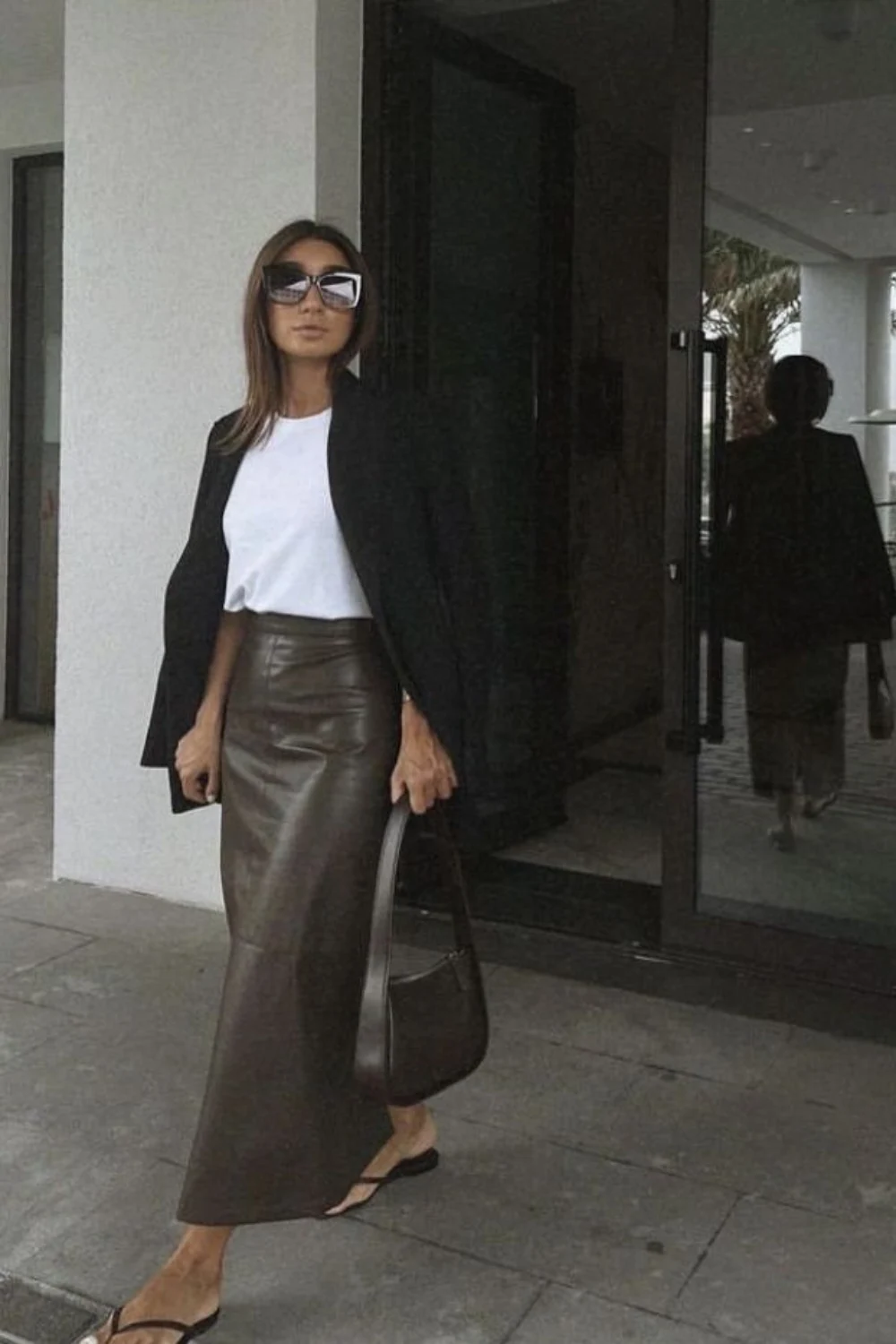 Minimal street style outfit with dark leather pencil skirt and white tee, showing clean lines and the versatility of a vintage leather skirt.