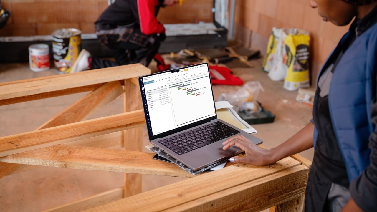 Monteure auf der Baustelle nutzen Flexxter App auf Laptop vor Ort