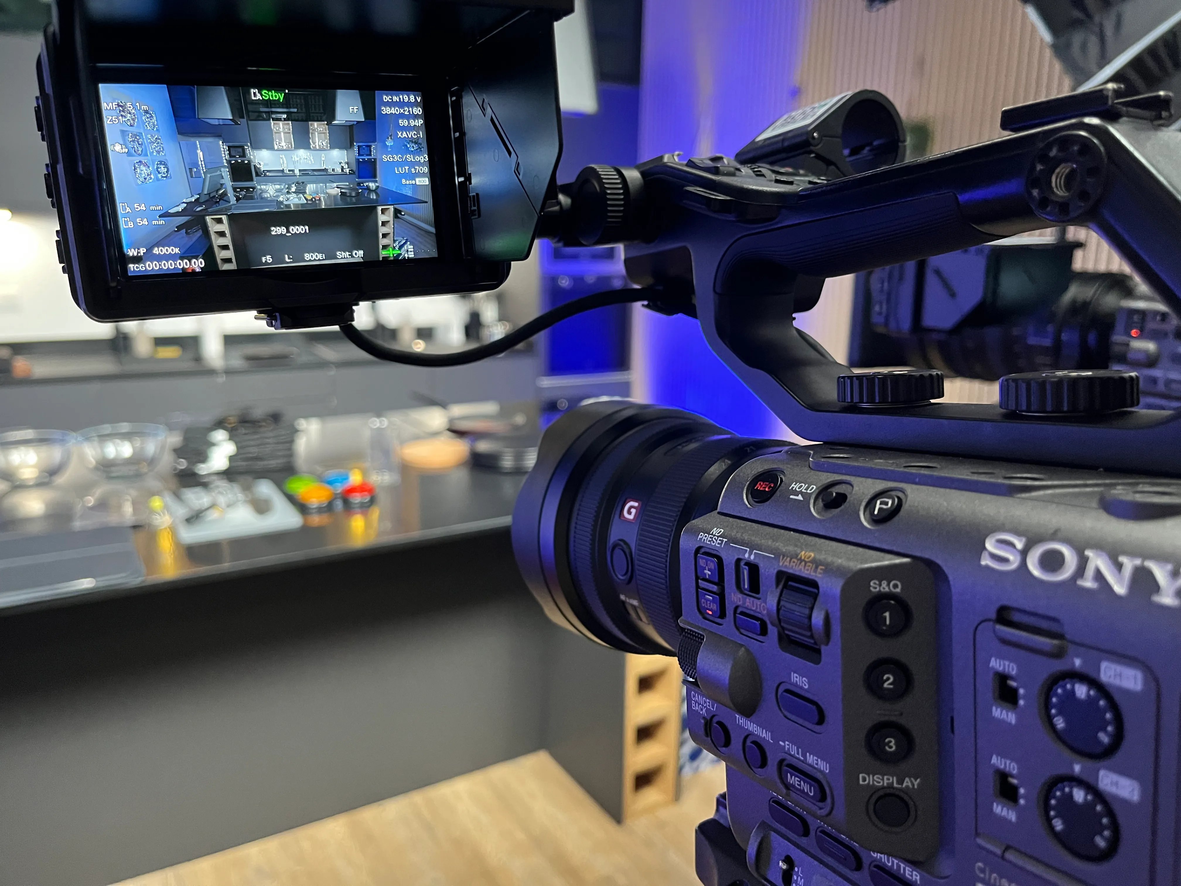 Caméra Sony professionnelle filmant un plan rapproché d'une cuisine moderne avec un écran affichant les réglages de la caméra.