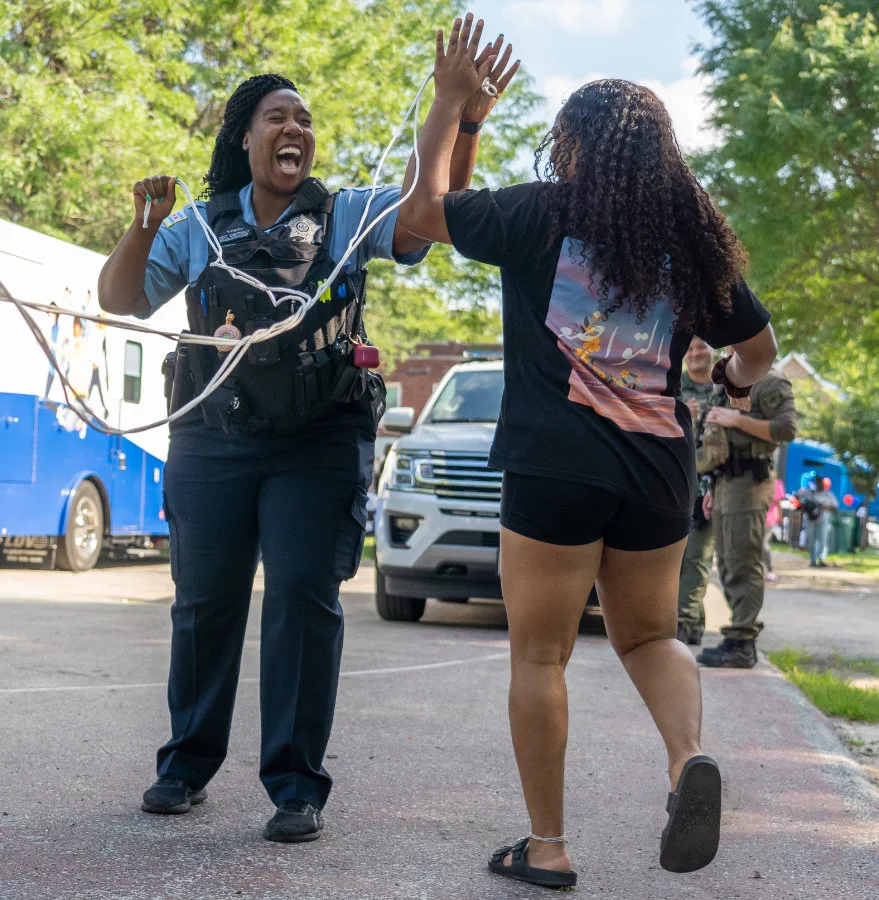 Female officer high-fiving girl