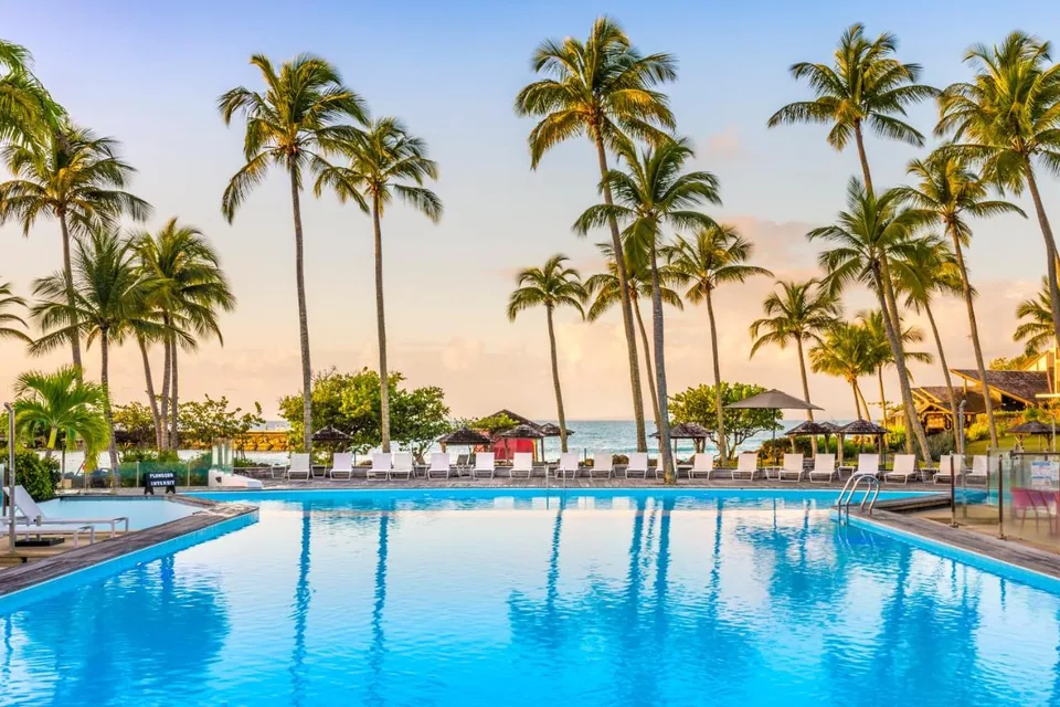 Piscine et palmiers au coucher du soleil - La Créole Beach Hôtel & Spa