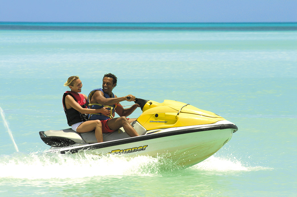 Couple profitant d’une balade en jet ski jaune sur une mer turquoise à Antigua dans les Caraïbes