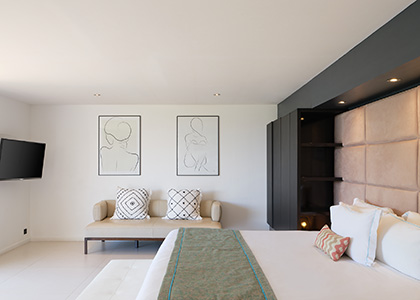 Coin salon et lit king size dans une chambre contemporaine de la Villa Ayati en Guadeloupe