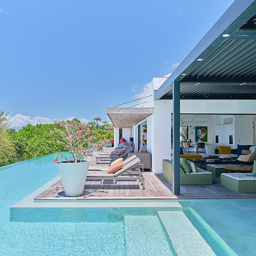 Terrasse de luxe avec salons d'extérieur et immense piscine à débordement de la Villa Ayati en Guadeloupe