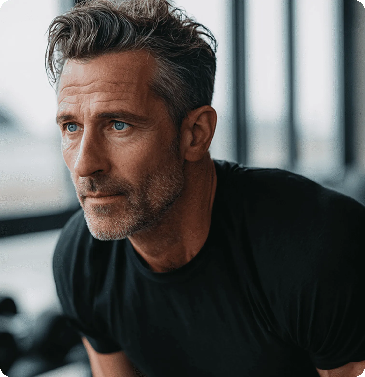 Middle-aged man with blue eyes and salt-and-pepper hair in a black shirt looking intently ahead.