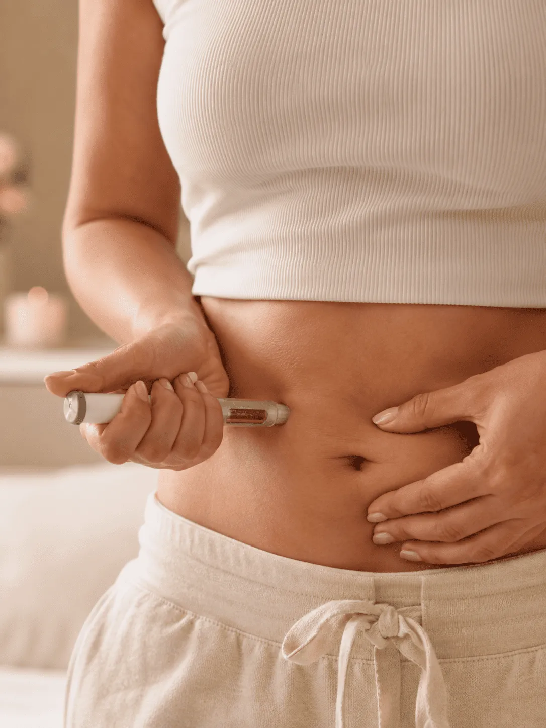 Person injecting medication into their abdomen using an insulin pen.
