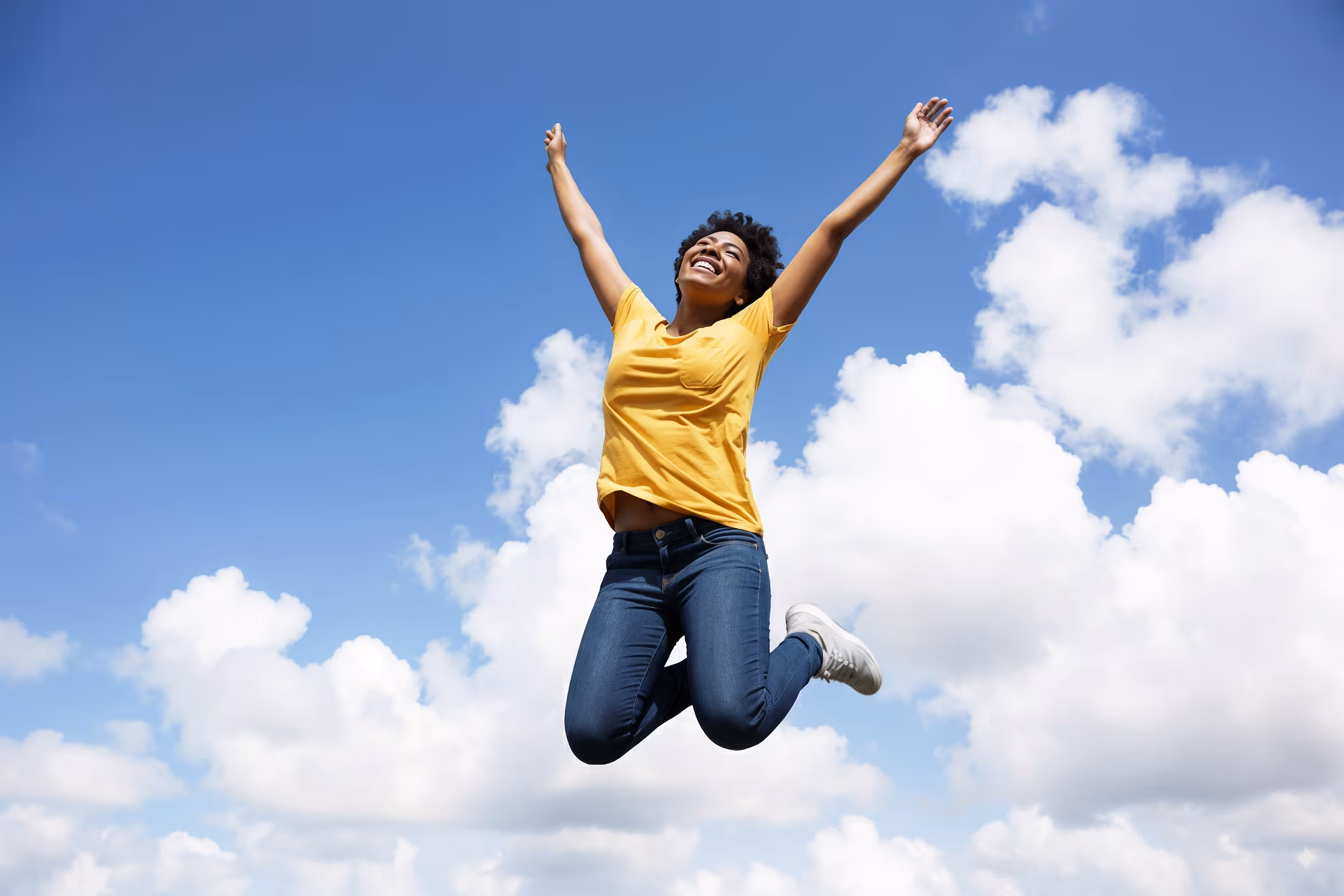 Vrouw springt blij in de lucht met armen omhoog tegen blauwe lucht, viert nieuwe levenskwaliteit na specialistische behandeling via Havena