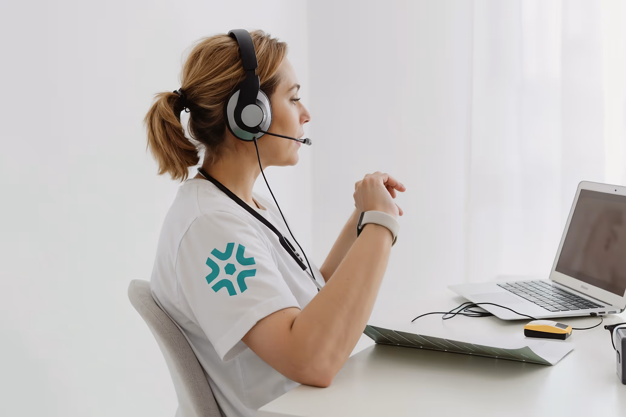 Zorgverlener met headset en Havena logo aan bureau helpt patiënt telefonisch met vragen over specialistische zorg en behandelopties