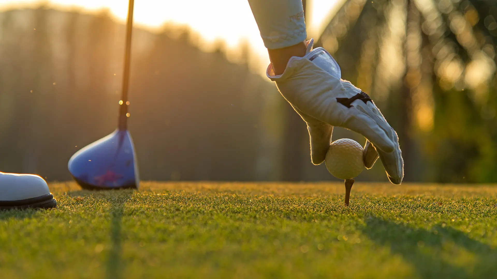 Golfer swinging on a golf course equipped with Qovoltis charging stations