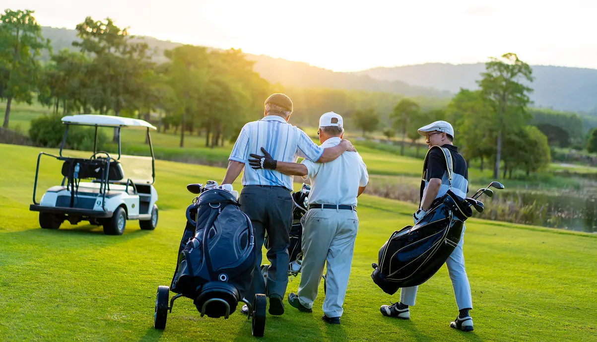 Golfers riding an electric cart on a golf course