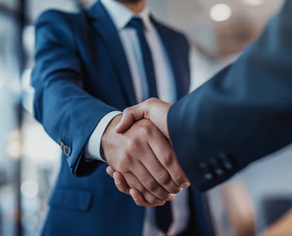 Two people wearing suits shaking hands