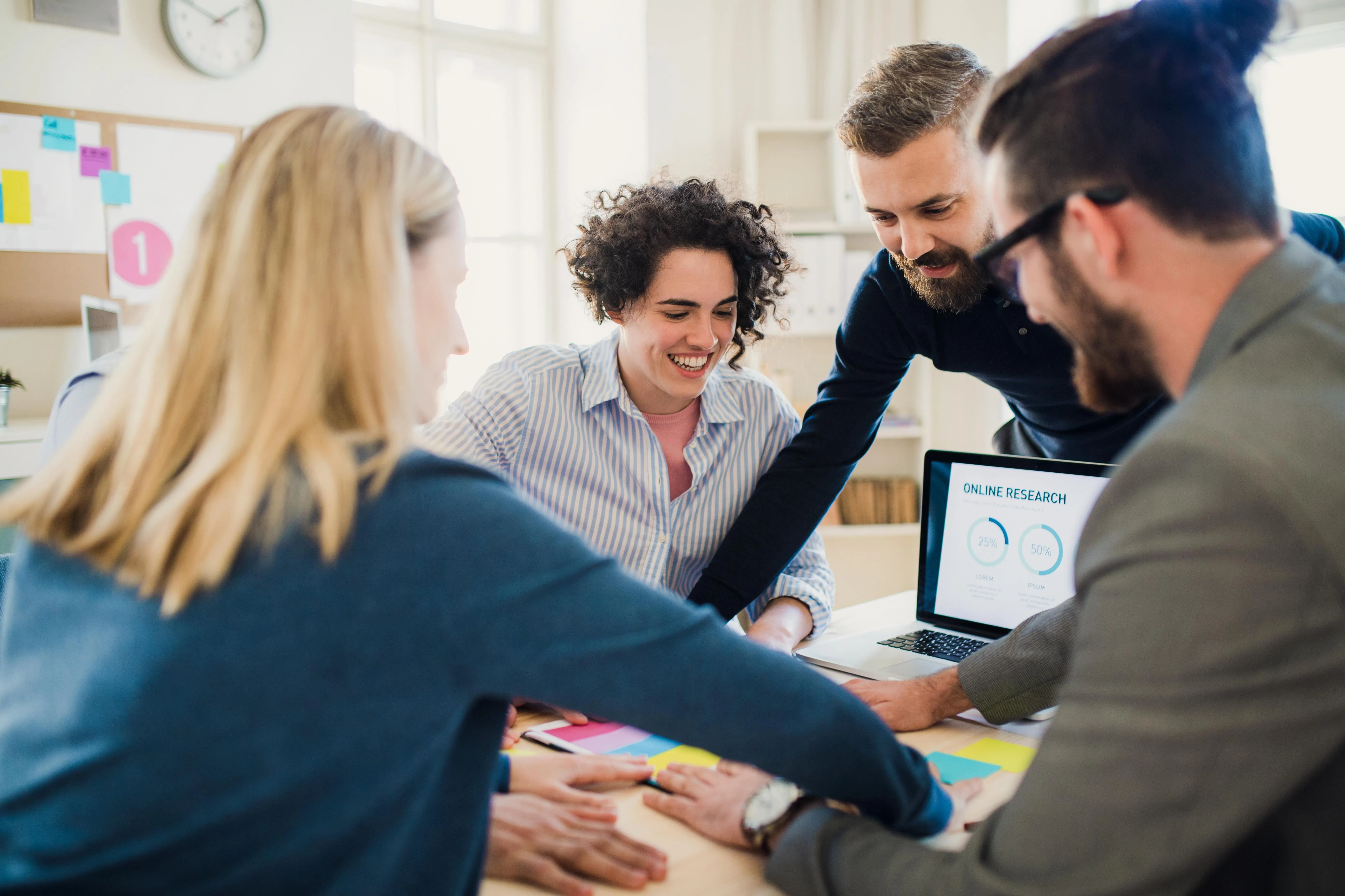 a group of people working together around a desk
