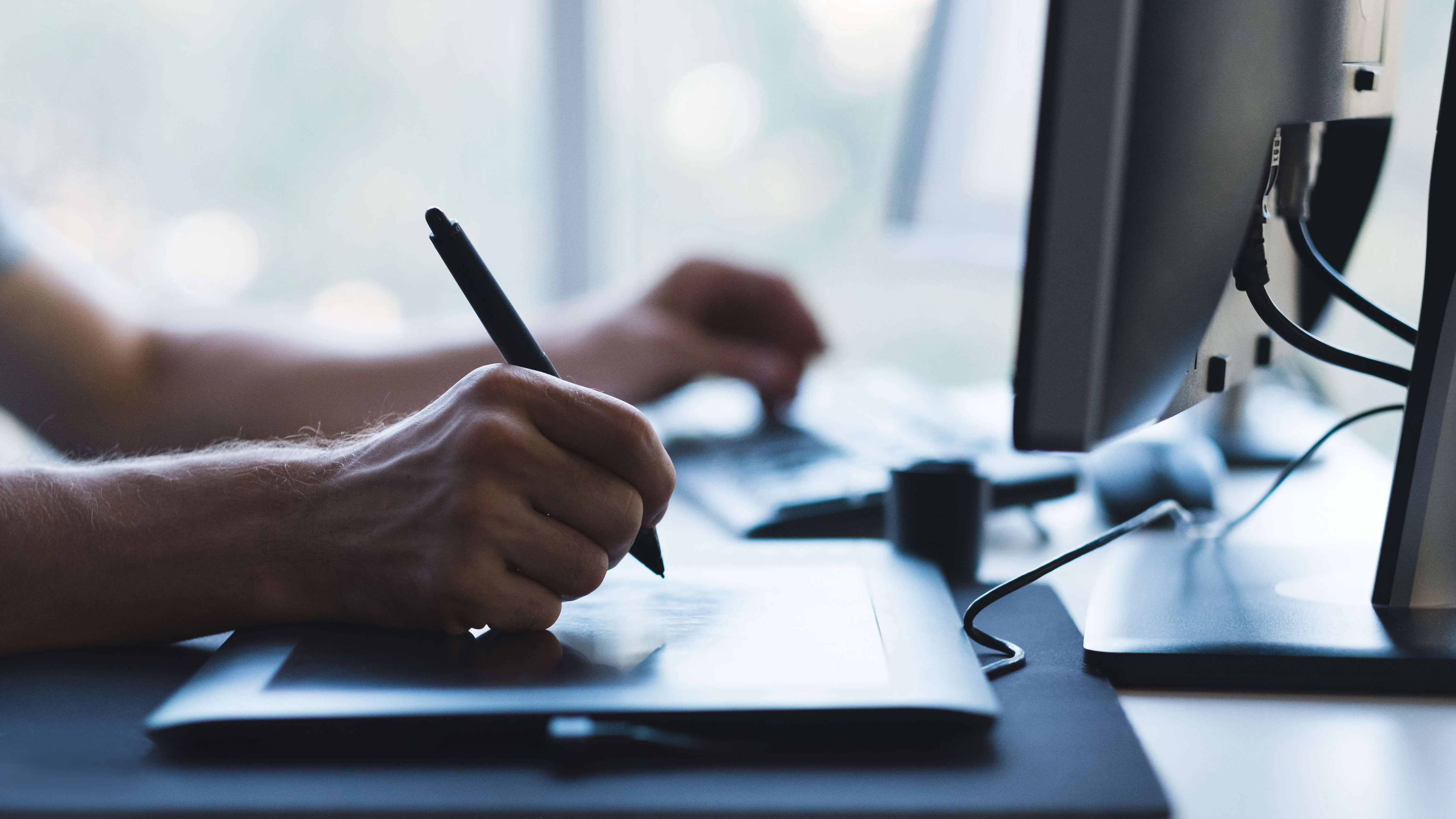 a mans hand typing on a laptop