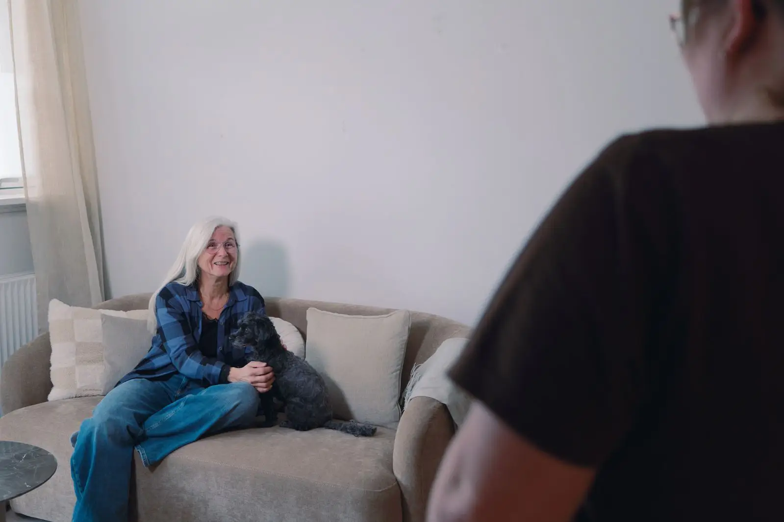 en husalf som står og snakker med en glad kunde