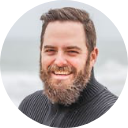 headshot of a man with beard smiling