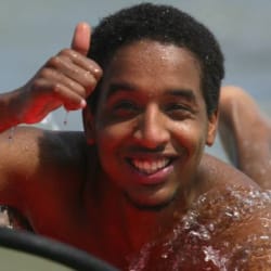 A man surfing and showing thumbs up pose for camera