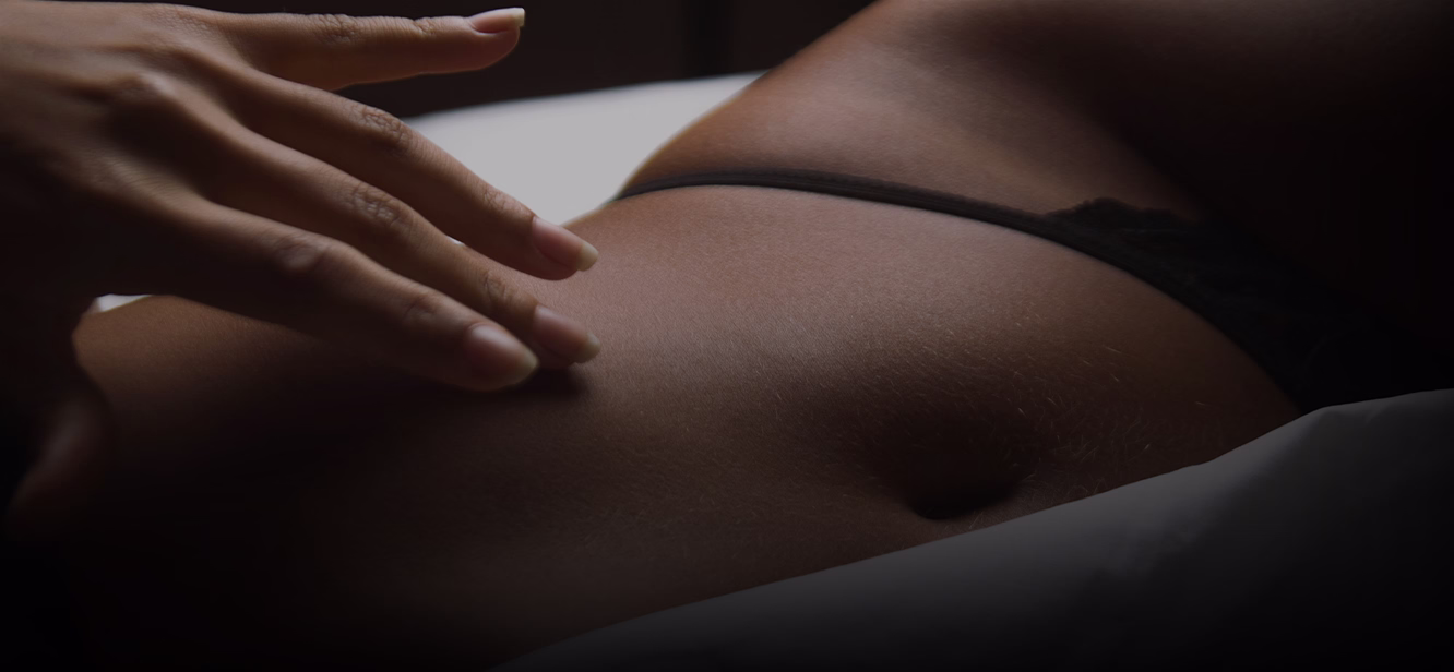 A close-up image of a person's abdomen, showing smooth skin and a hand gently resting on it.