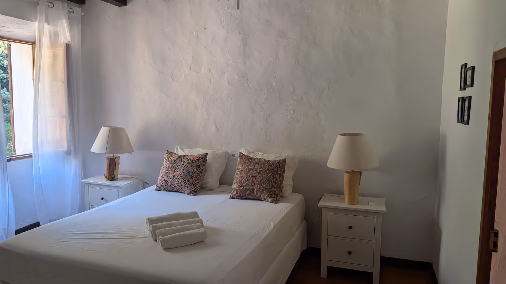 Minimalist guest room with whitewashed walls, twin beds pushed together, and soft-toned decor at Finca Higo.