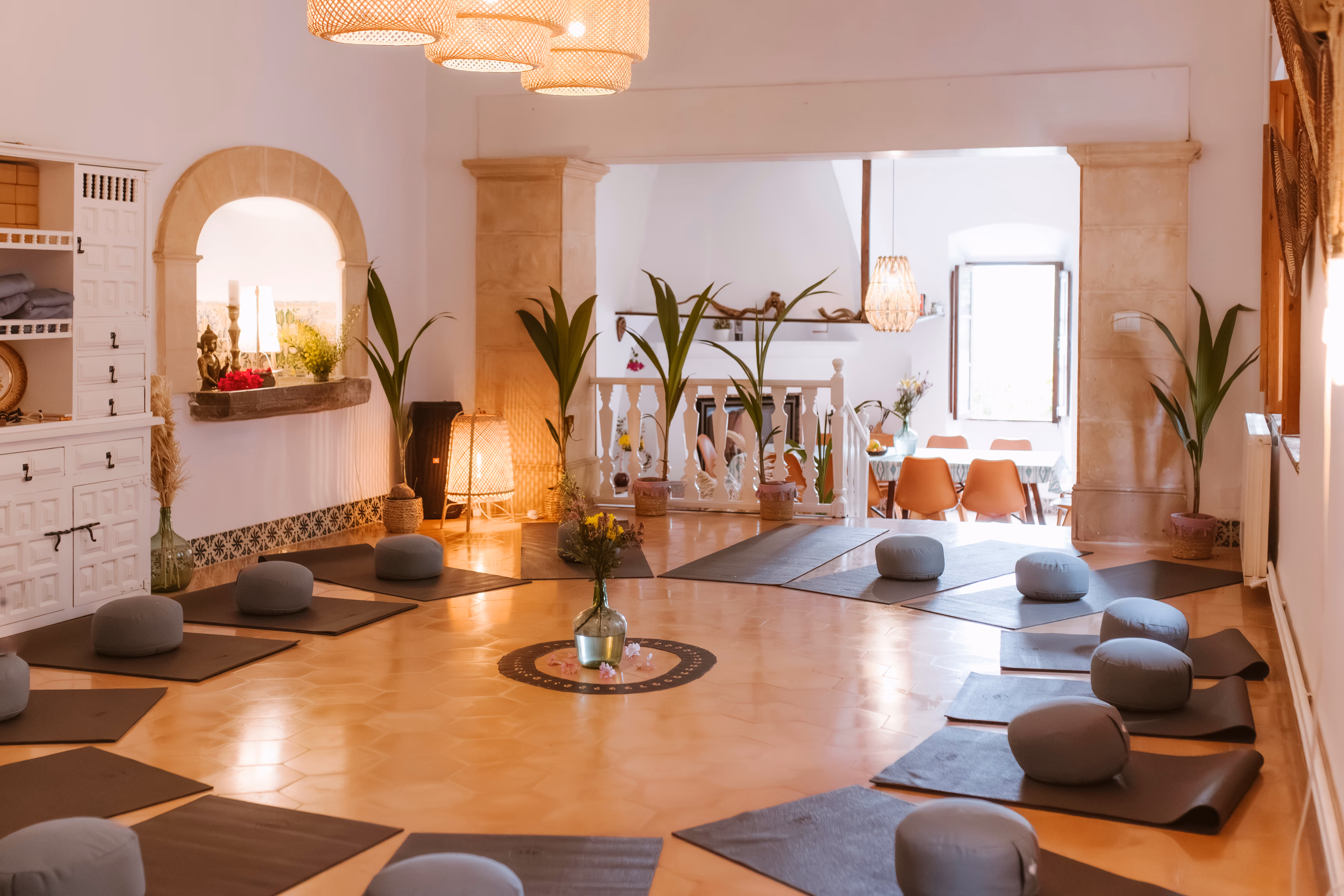 Indoor yoga shala at Finca Higo with yoga mats, meditation cushions, and plants in a warm, charming room.