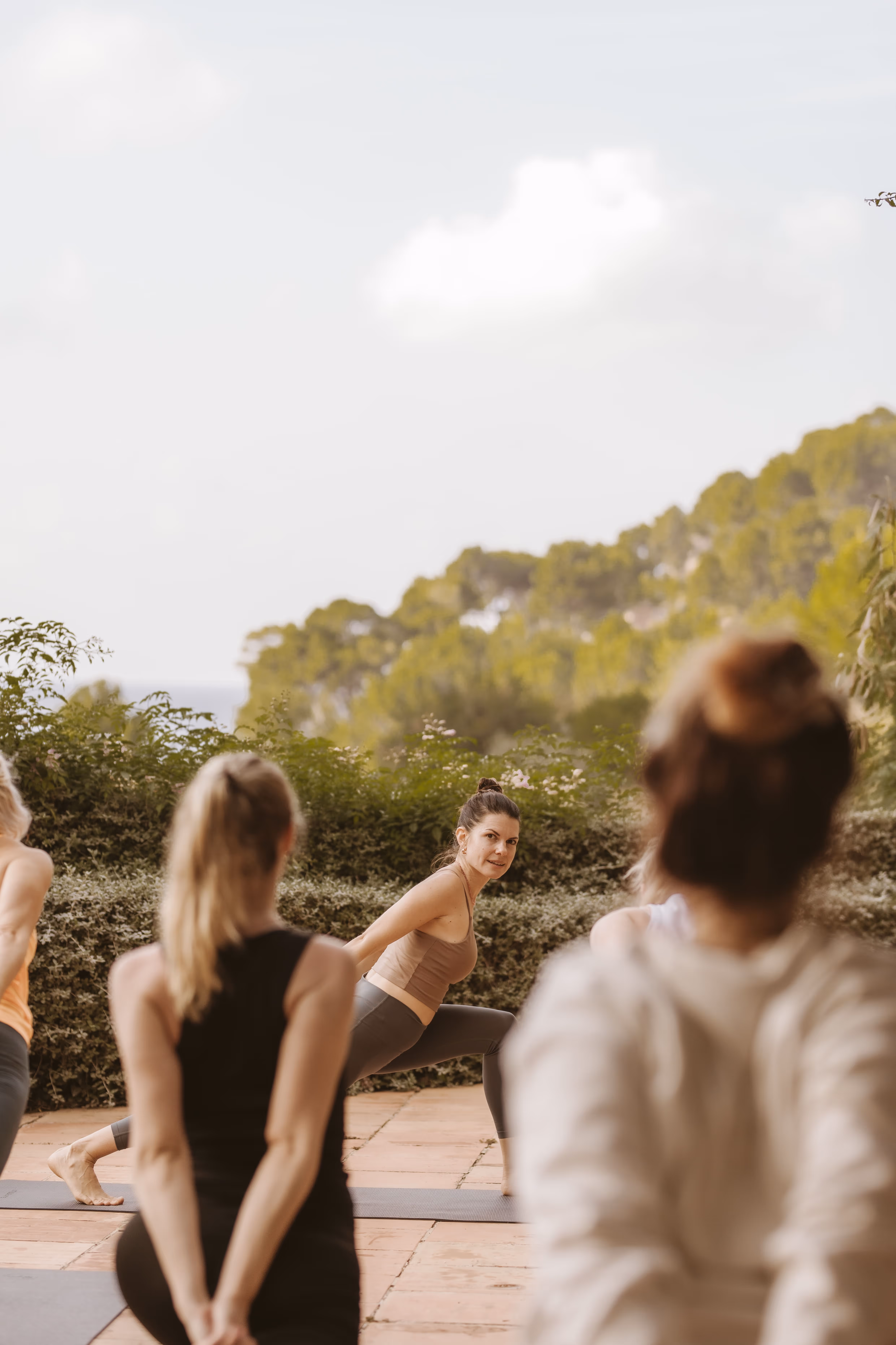 Yoga teacher guiding a yoga session on the terrace at Finca Higo, with participants practicing outdoors.