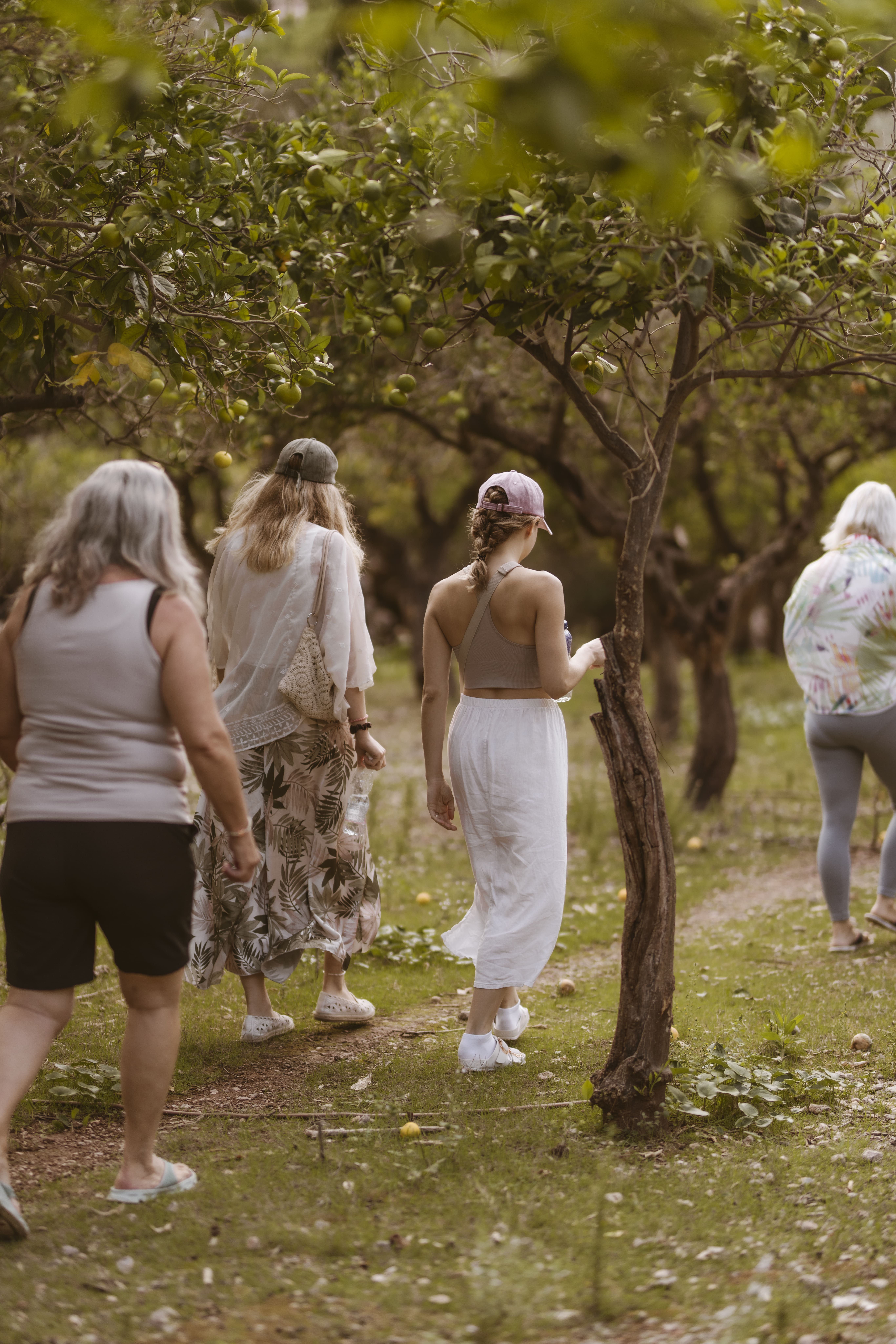 Women walking through gardens and trees, exploring the natural landscape on a hike.