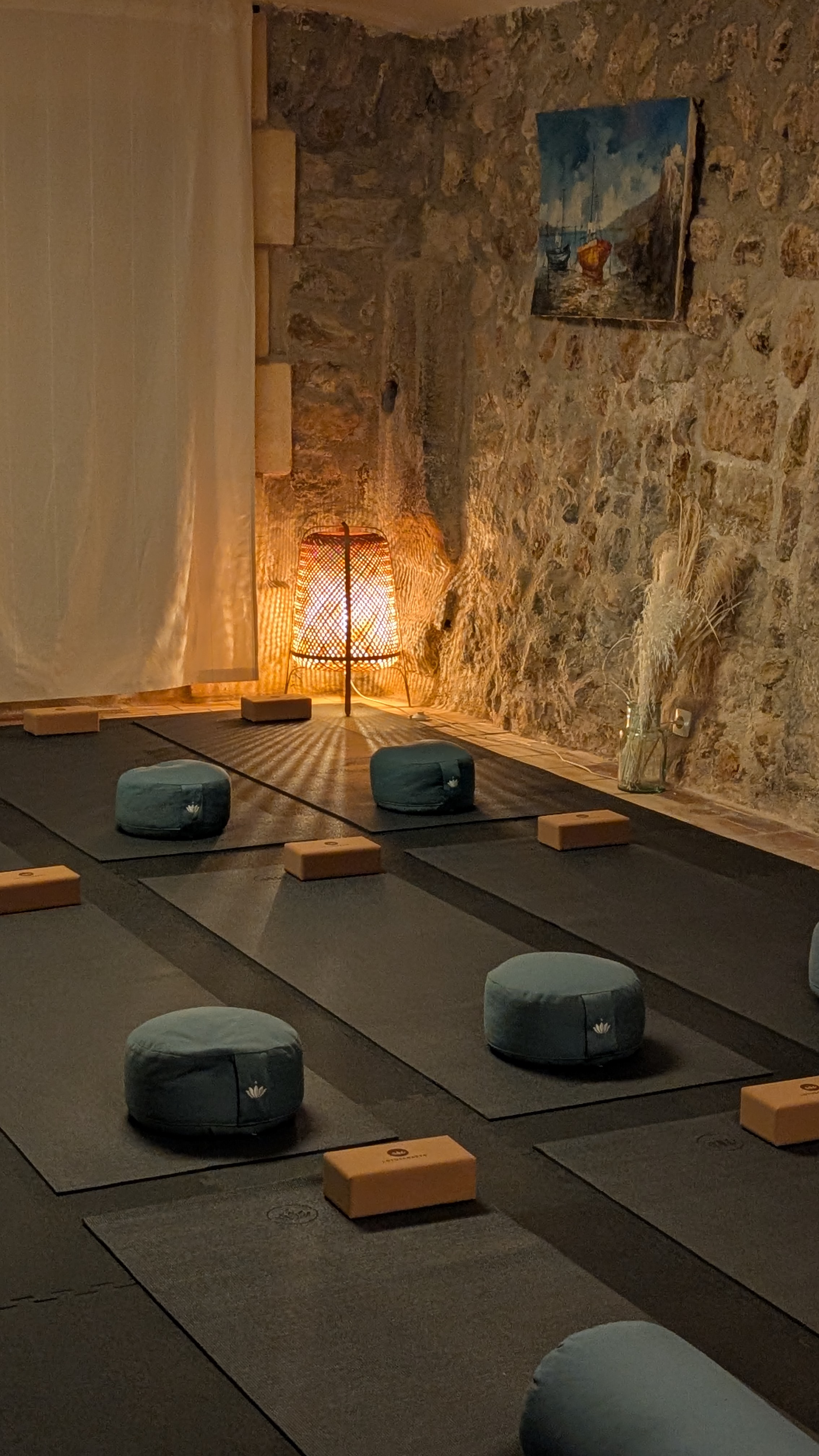 Women approaching a historic farmhouse in Cala Tuent, with the Tramuntana Mountains in front.