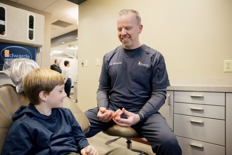 Dentist explaining treatment to young child patient in clinical setting