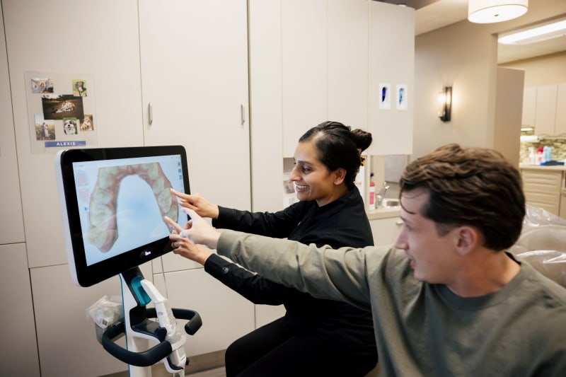Dental professional reviewing digital imaging with patients during consultation