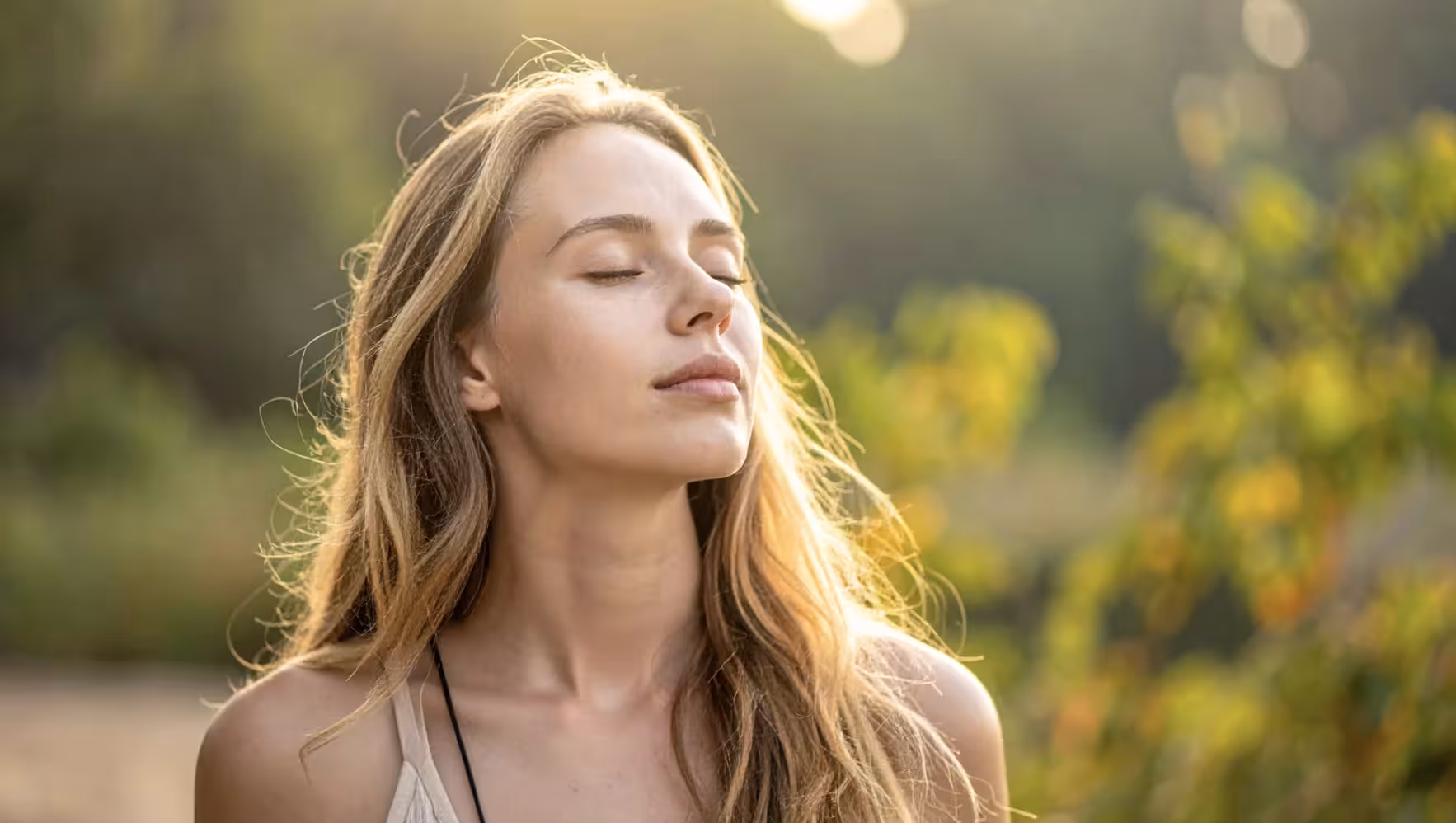 Woman pausing outdoors in warm sunlight