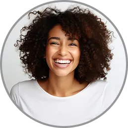 Smiling woman with curly hair wearing a white shirt against a neutral background.