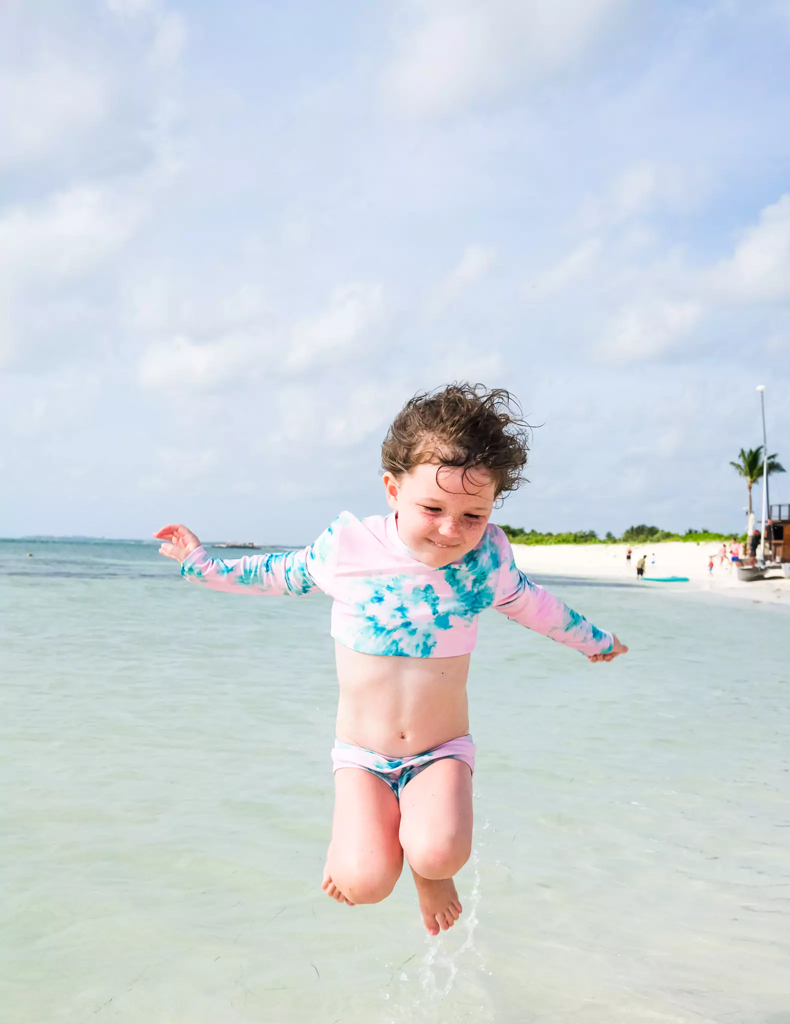 Child jumping in the calm ocean at Etereo