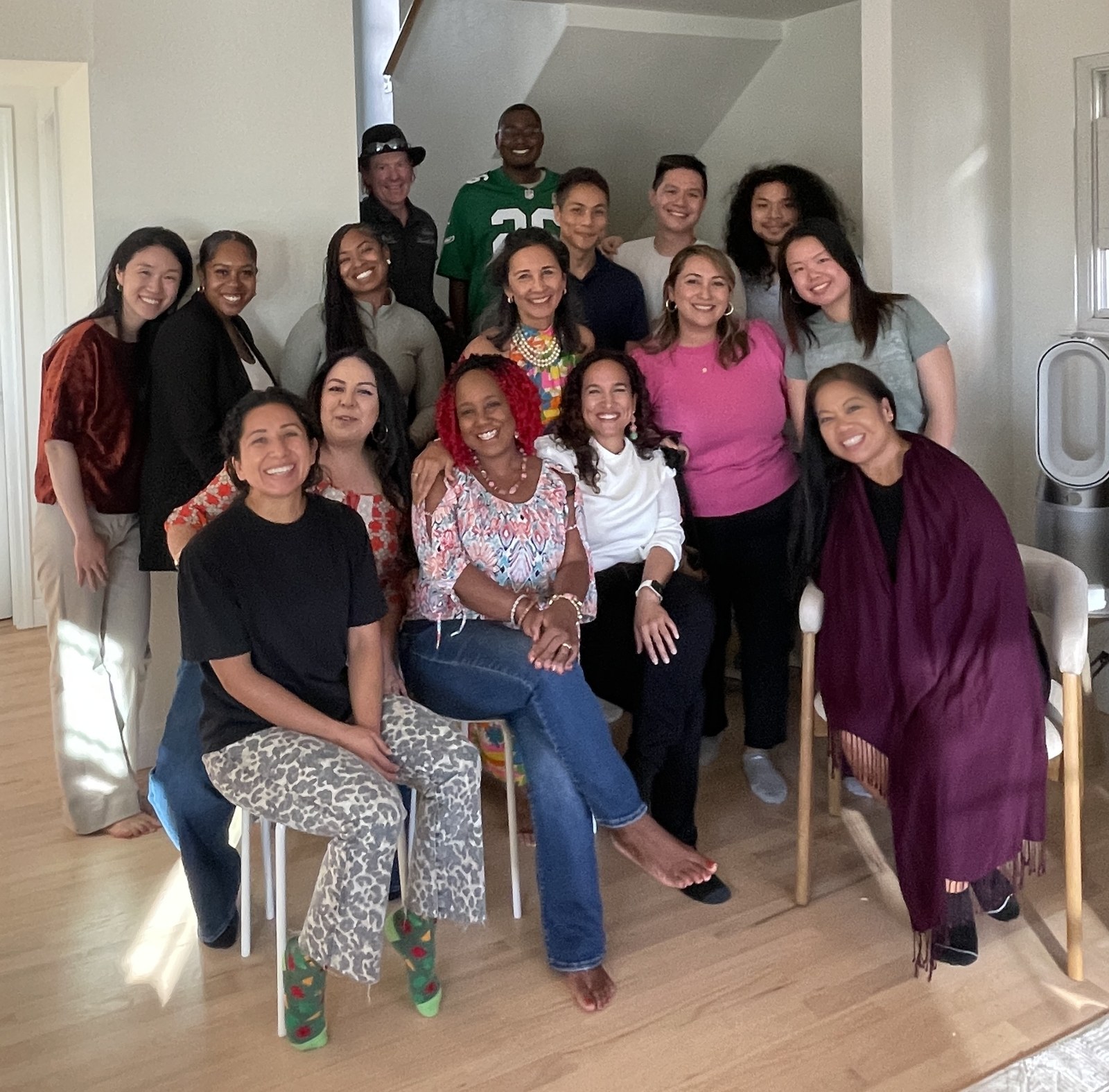 A group smiling together in a bright indoor gathering space.