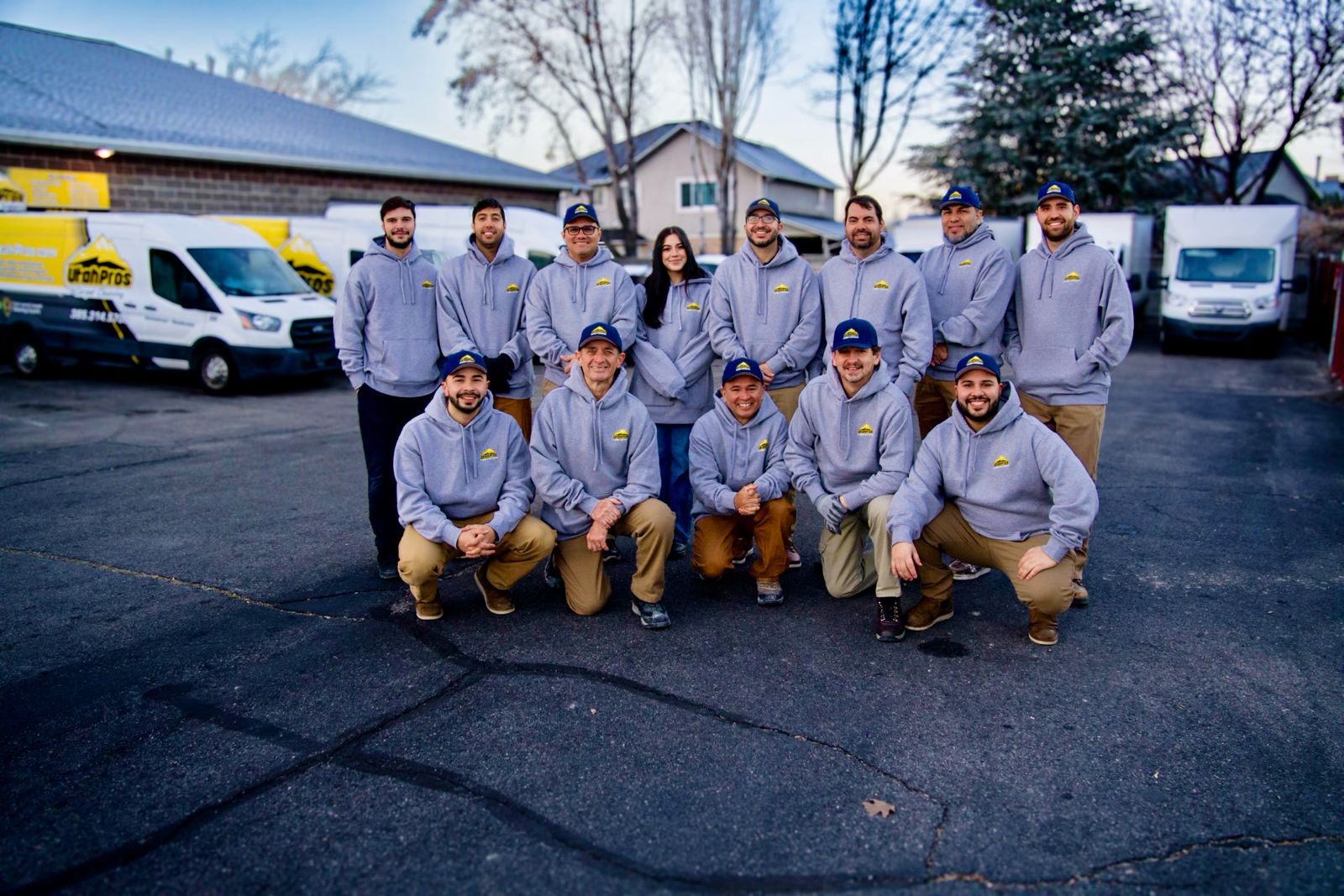 The Utah Pros restoration crew in branded uniforms in front of their service vans in Utah County