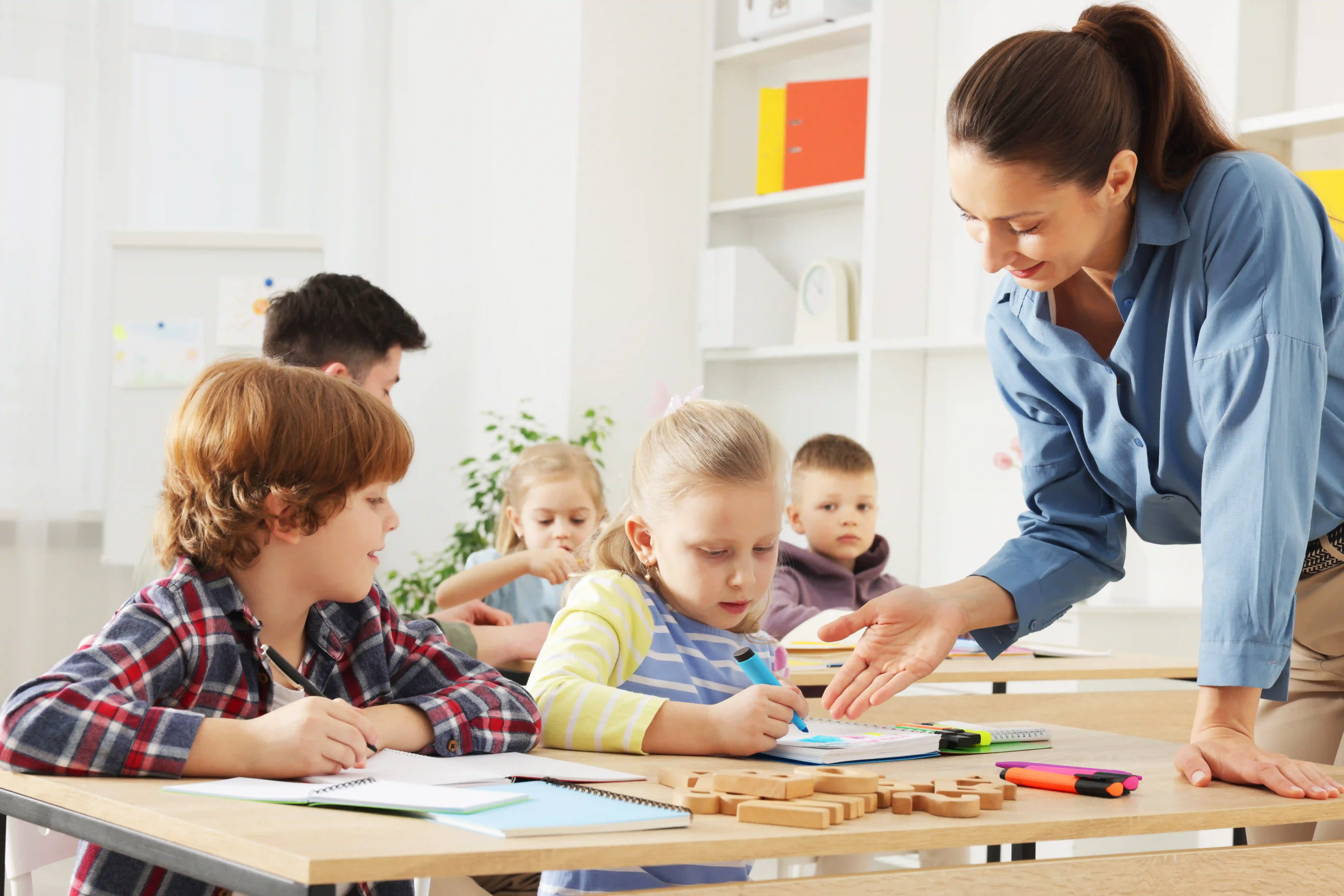 Young students learning with their teacher in a classroom