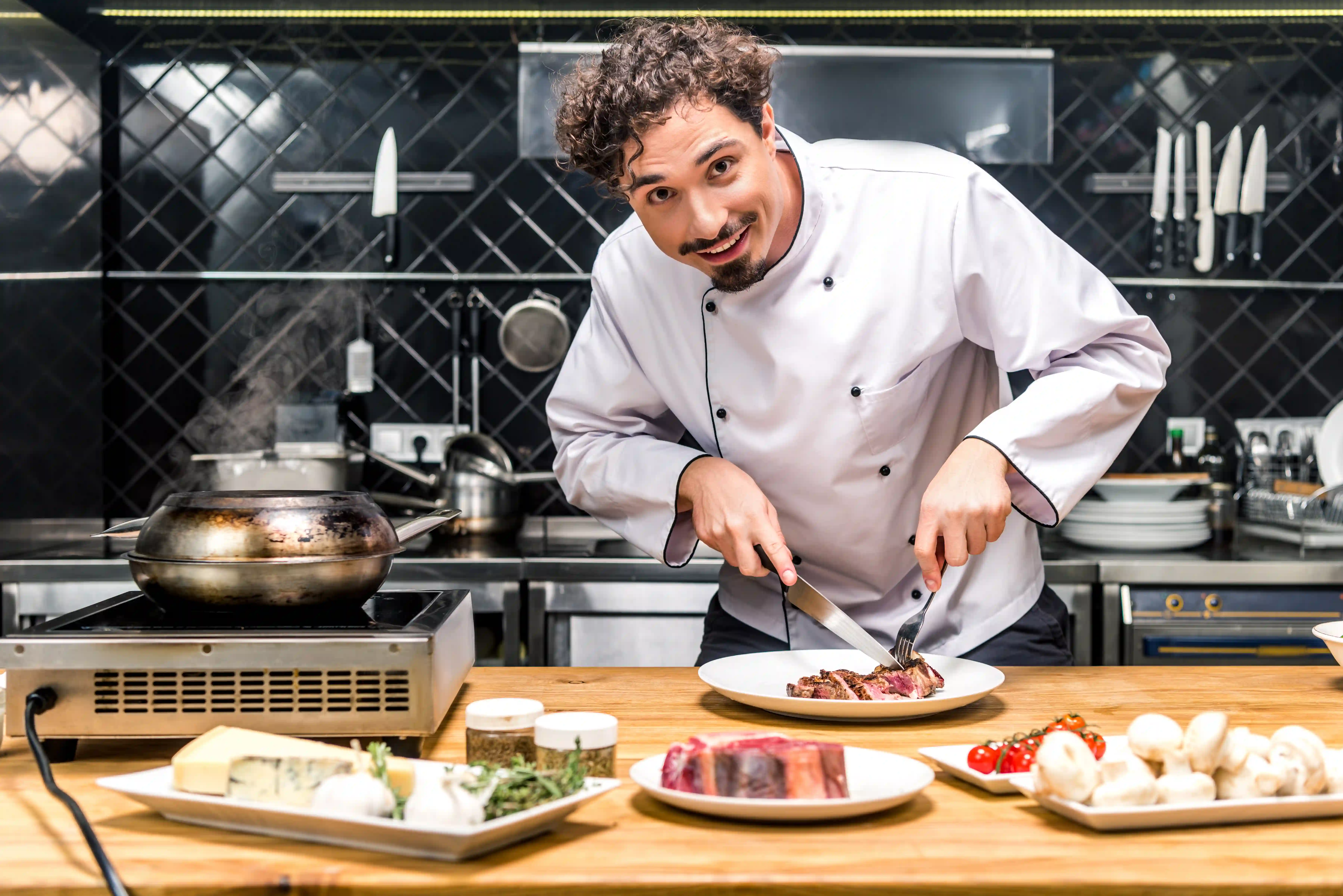 Professional chef preparing steak in a restaurant kitchen