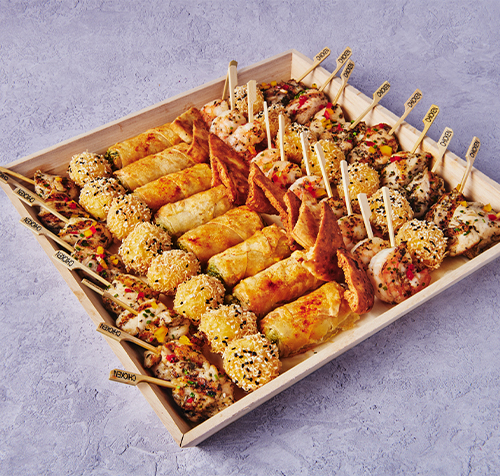 Athenian catering tray with Mediterranean skewers, pita, cheese bites, and assorted Greek-style appetizers.