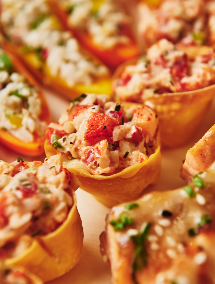 Mini lobster salad cups in crisp shells with herbs and diced vegetables.