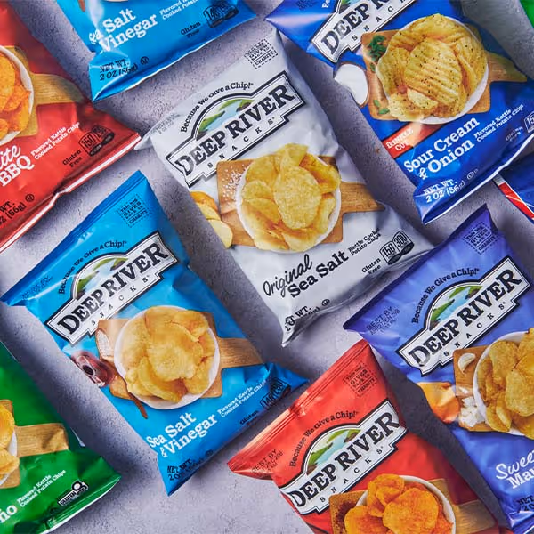 Assorted Deep River potato chip bags arranged on a light gray surface.