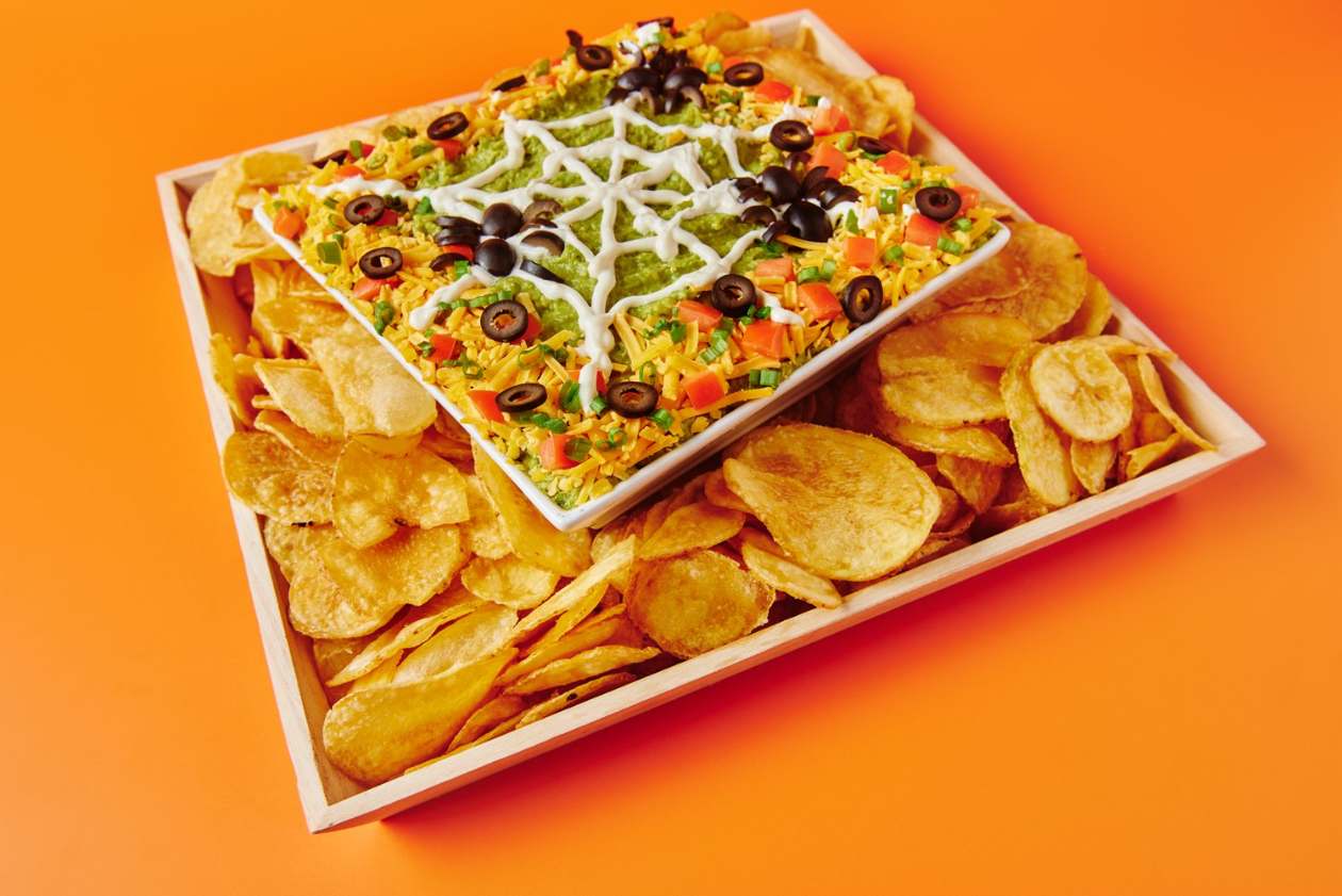 Spider web layer dip with sour cream web, olive spiders and kettle chips (VEG GF)