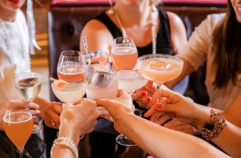 Guests raising cocktail glasses at an office holiday party